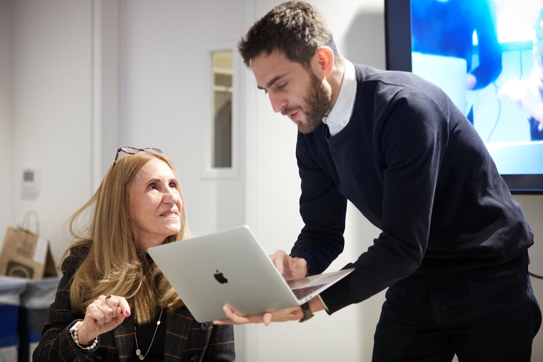 Man with laptop in discussion with woman.